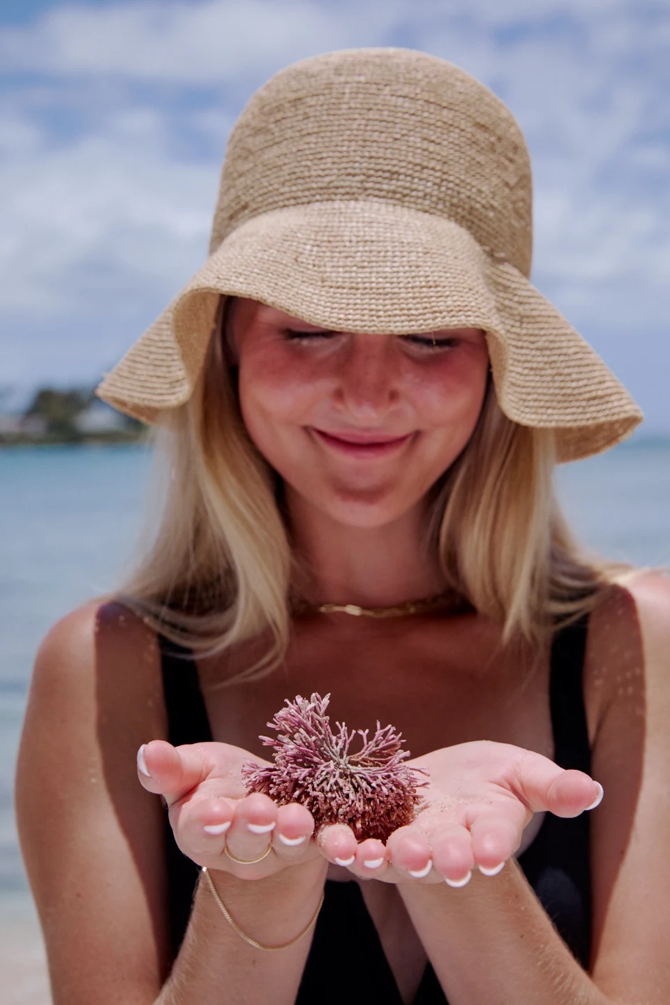 Emma at the ocean holding a sea urchin