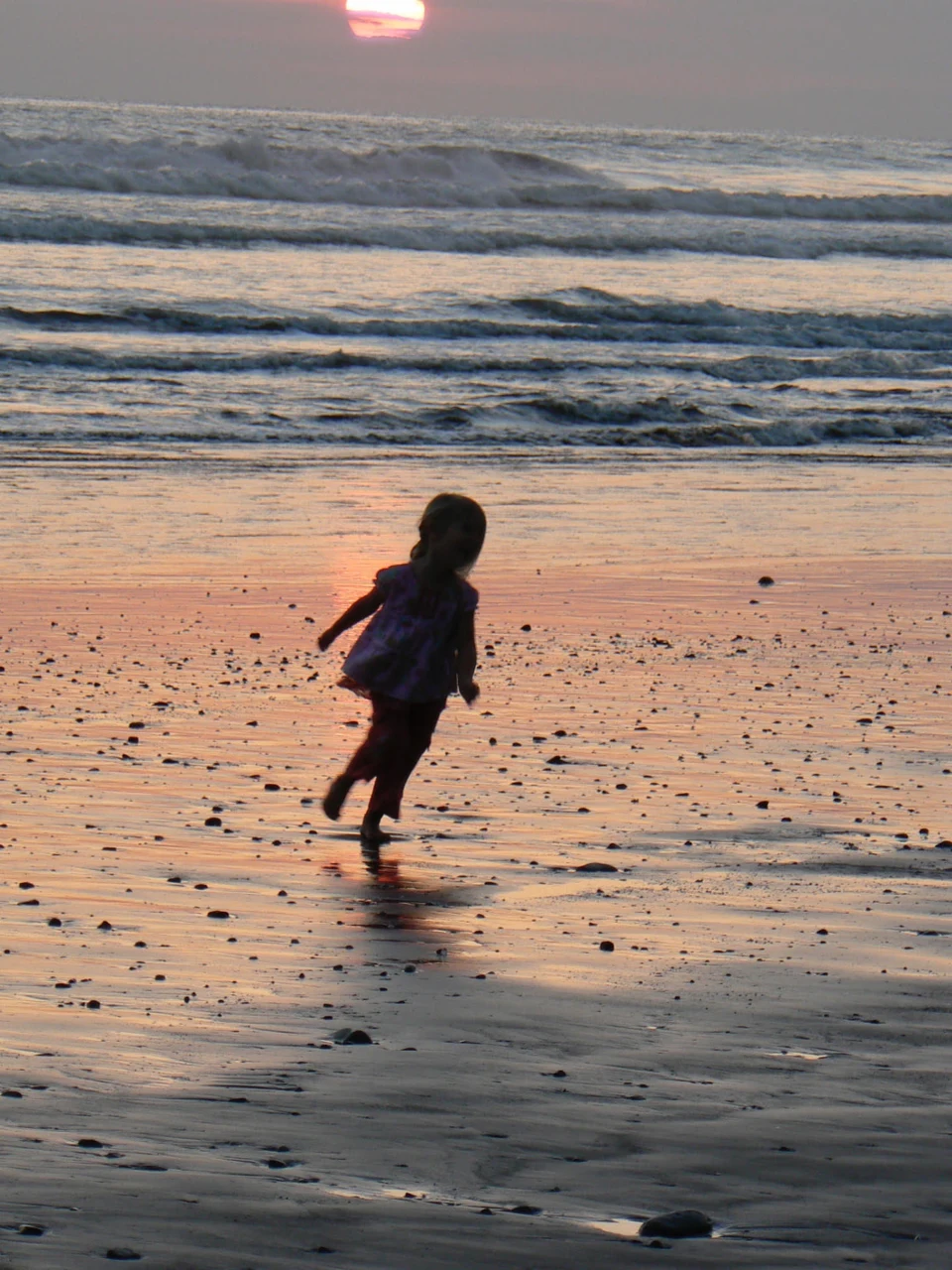 Emma as a child running along the beach at sunset